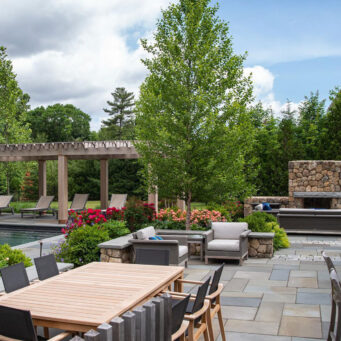 Luxury pool terrace with pergola, outdoor fireplace, and lounge zones adds resort‑style comfort and refined details for summer relaxation.