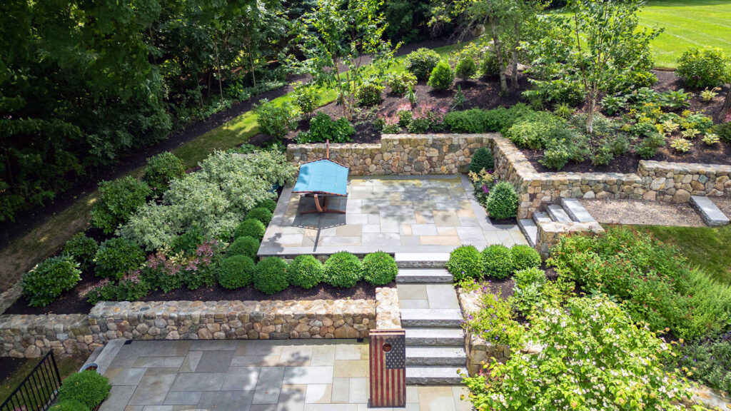 Multi‑level terrace with stone walls and a secluded seating nook blends natural texture and thoughtful layout for cozy relaxation amid lush plantings.
