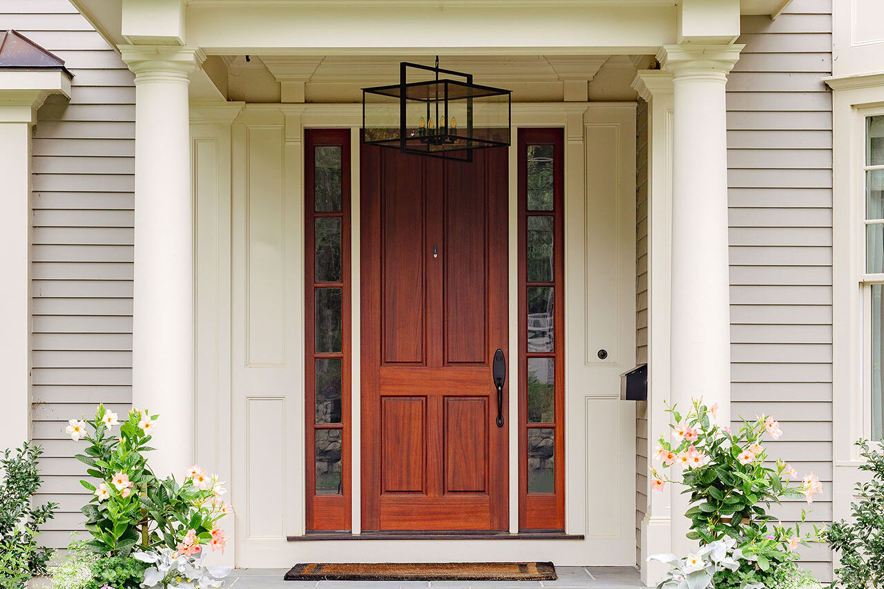 Paired urns filled with flowering annuals reinforce the symmetry of a formal colonial entry and allow for easy summer color changes.