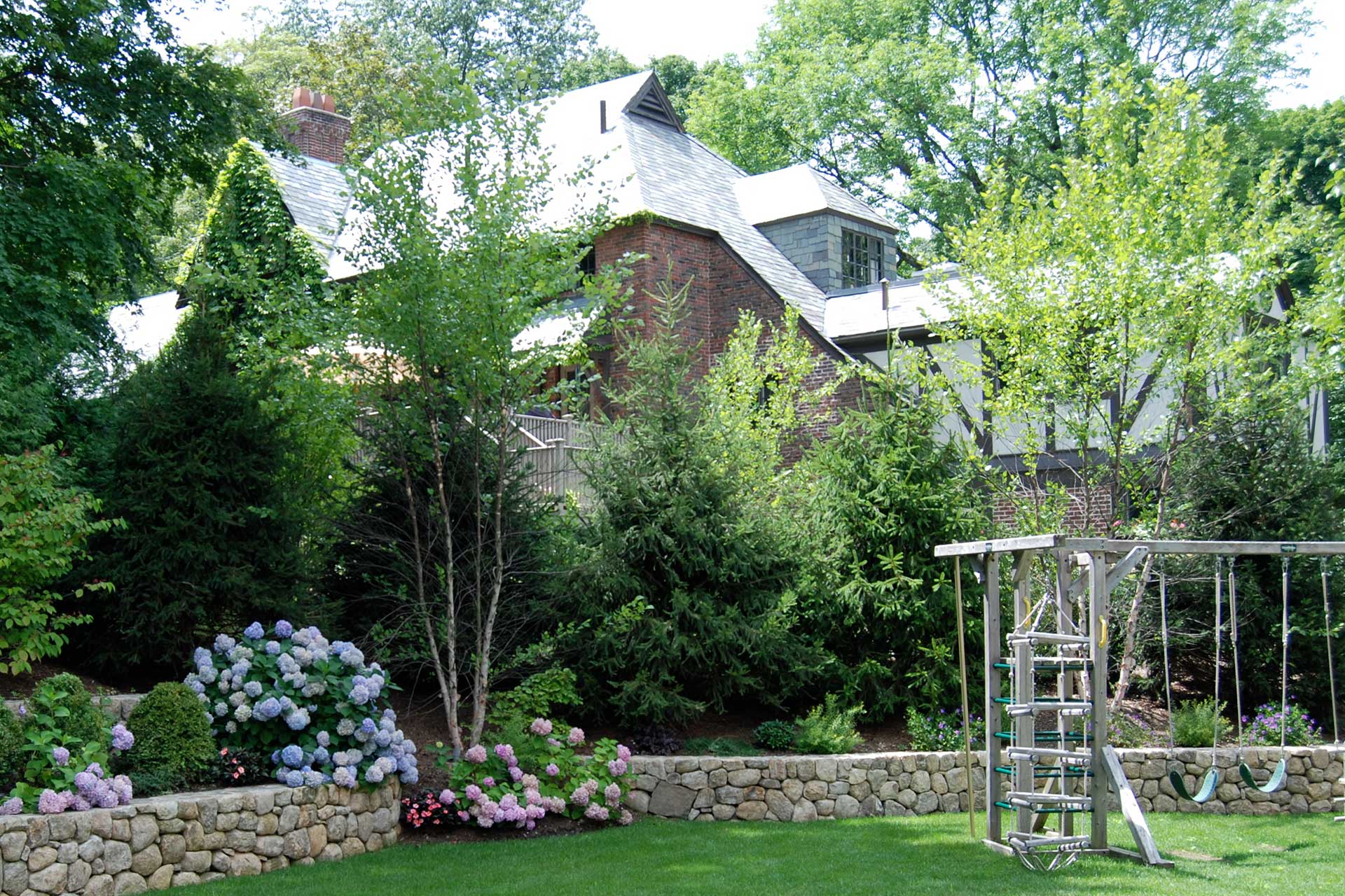 Trees and hedges enclose this play area, creating a safer, more private space for children within the landscape.